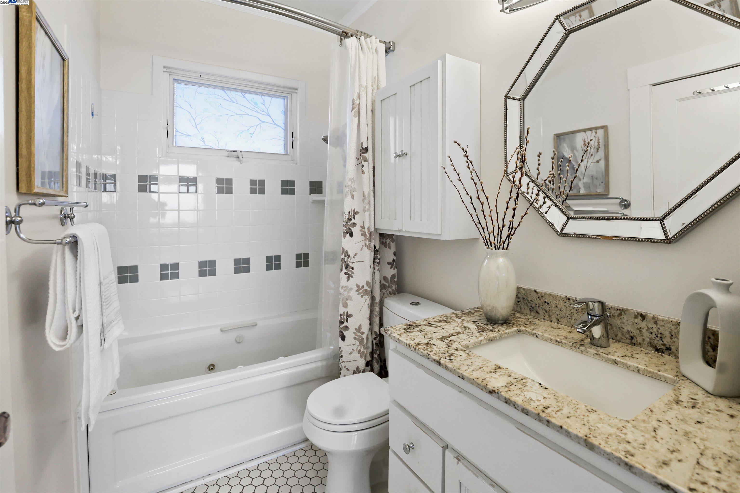 1361 Oakland Avenue Piedmont, CA 94611 - Photo 23 of 27 a bathroom with a granite countertop sink a toilet and a bathtub