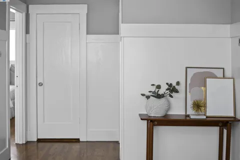 a dining room with wooden floor and white walls