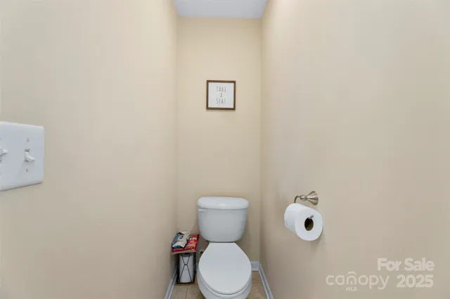 a white toilet sitting next to a white wall