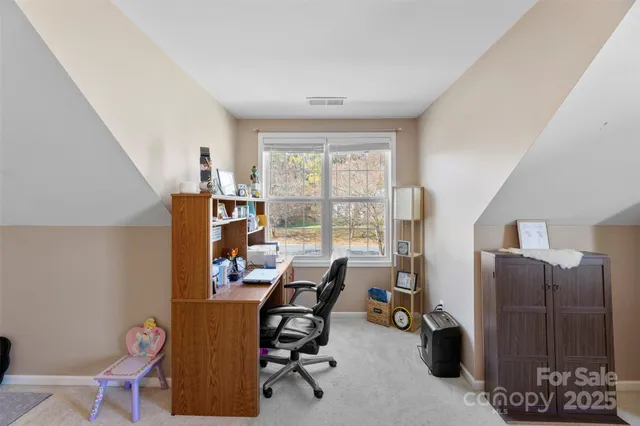 a view of a workspace with furniture and a window