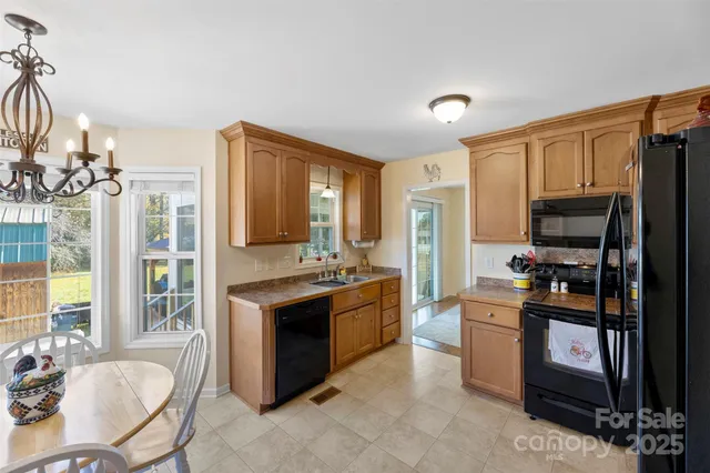 a kitchen with stainless steel appliances granite countertop a stove top oven a sink dishwasher a dining table and chairs with wooden floor