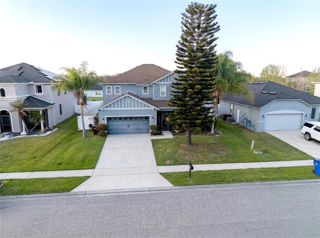 a view of house with a yard and a garage