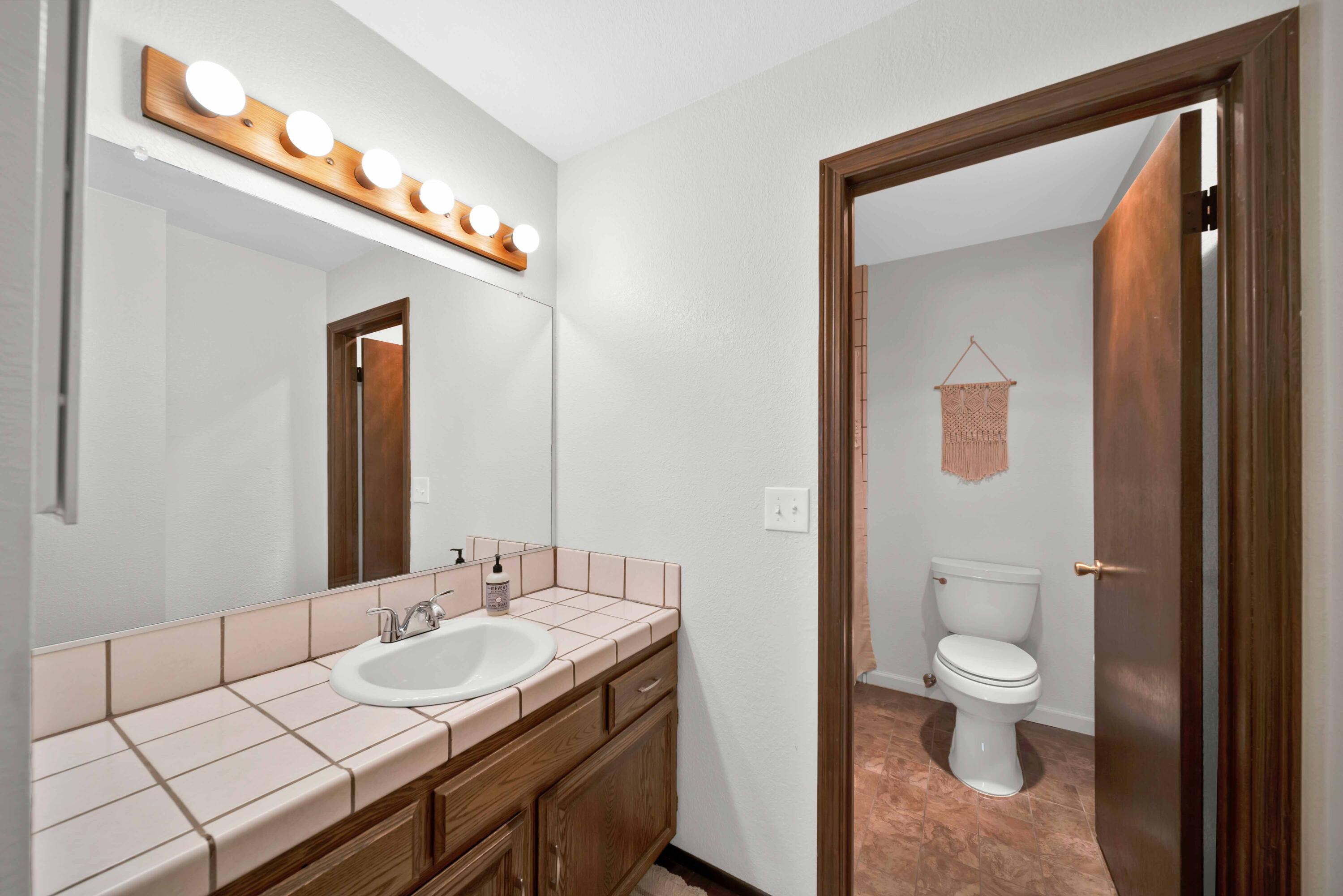 249 Ridgetop Drive, Unit 239 Redding, CA 96003 - Photo 24 of 31 a en suite bathroom with a granite countertop sink a toilet and a mirror