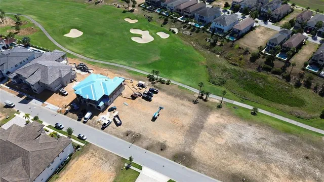 an aerial view of a residential houses with yard