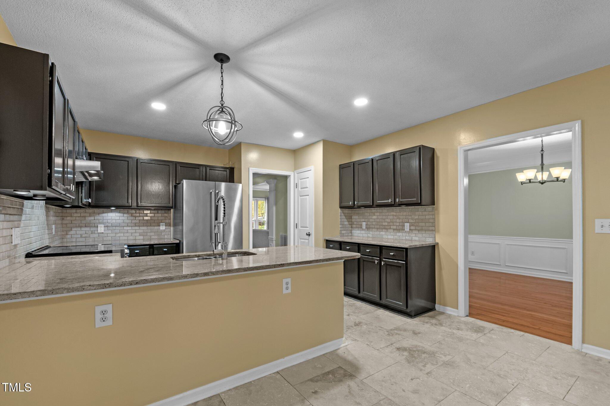 6209 Brielson Place Raleigh, NC 27616 - Photo 15 of 41 a large kitchen with stainless steel appliances granite countertop a sink and a refrigerator