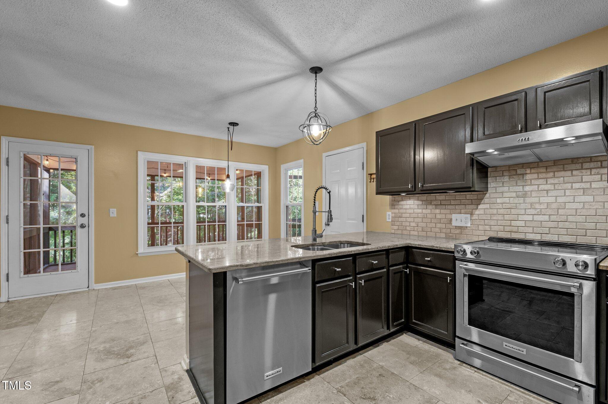 6209 Brielson Place Raleigh, NC 27616 - Photo 17 of 41 a kitchen with stainless steel appliances granite countertop a sink and a stove