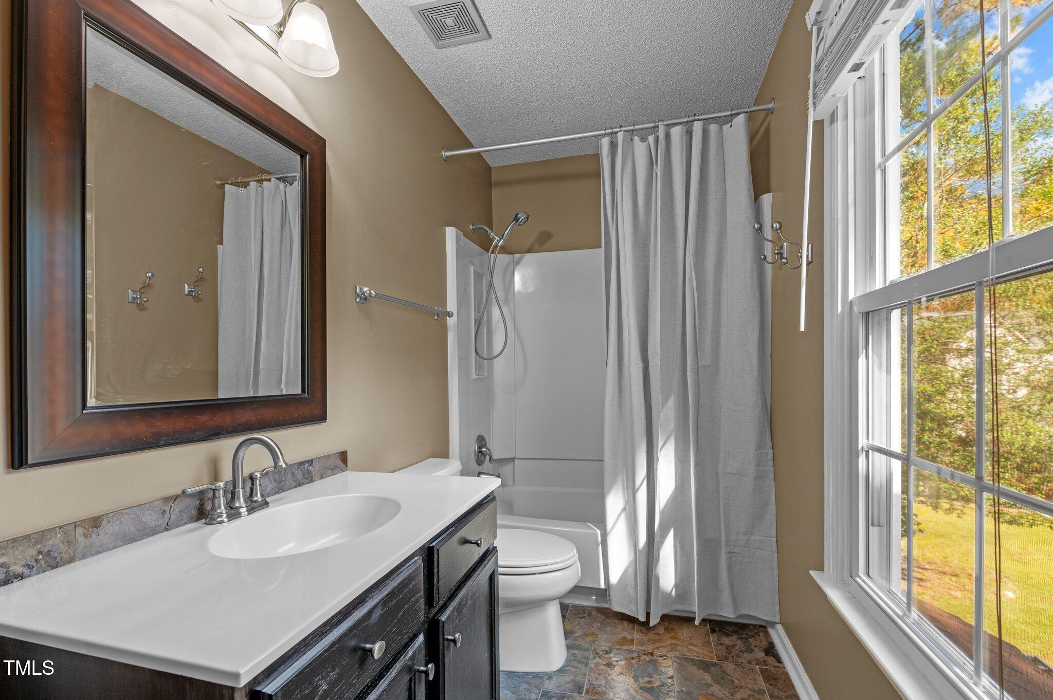 6209 Brielson Place Raleigh, NC 27616 - Photo 25 of 41 a bathroom with a sink a toilet a large mirror and shower