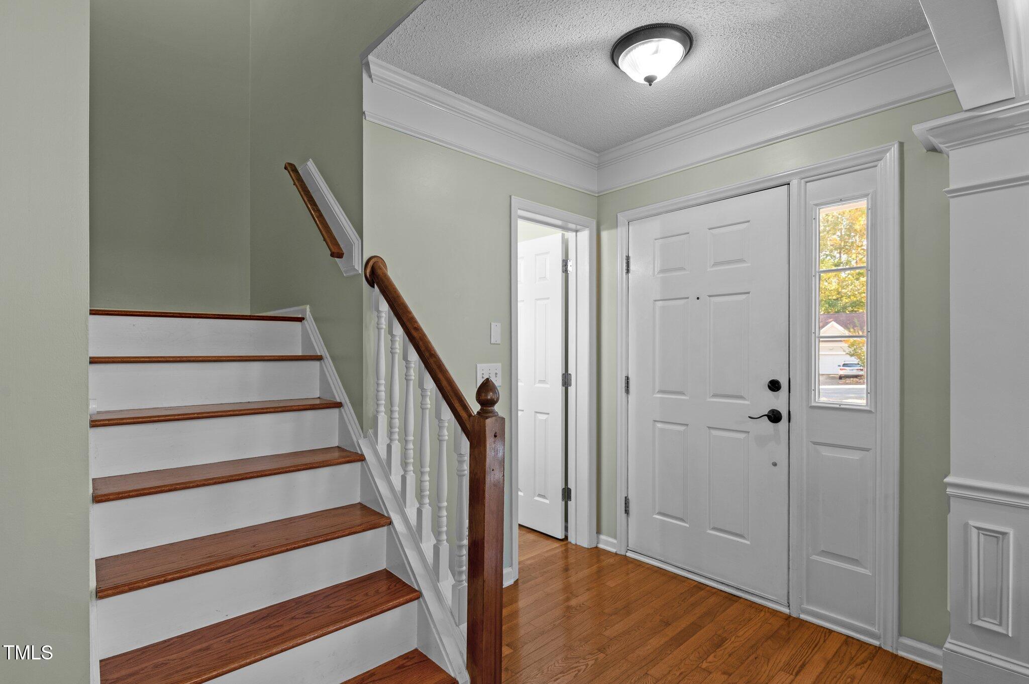 6209 Brielson Place Raleigh, NC 27616 - Photo 5 of 41 a view of entryway with wooden floor and stairs