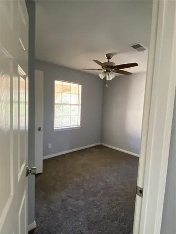 a view of a livingroom with a ceiling fan and window