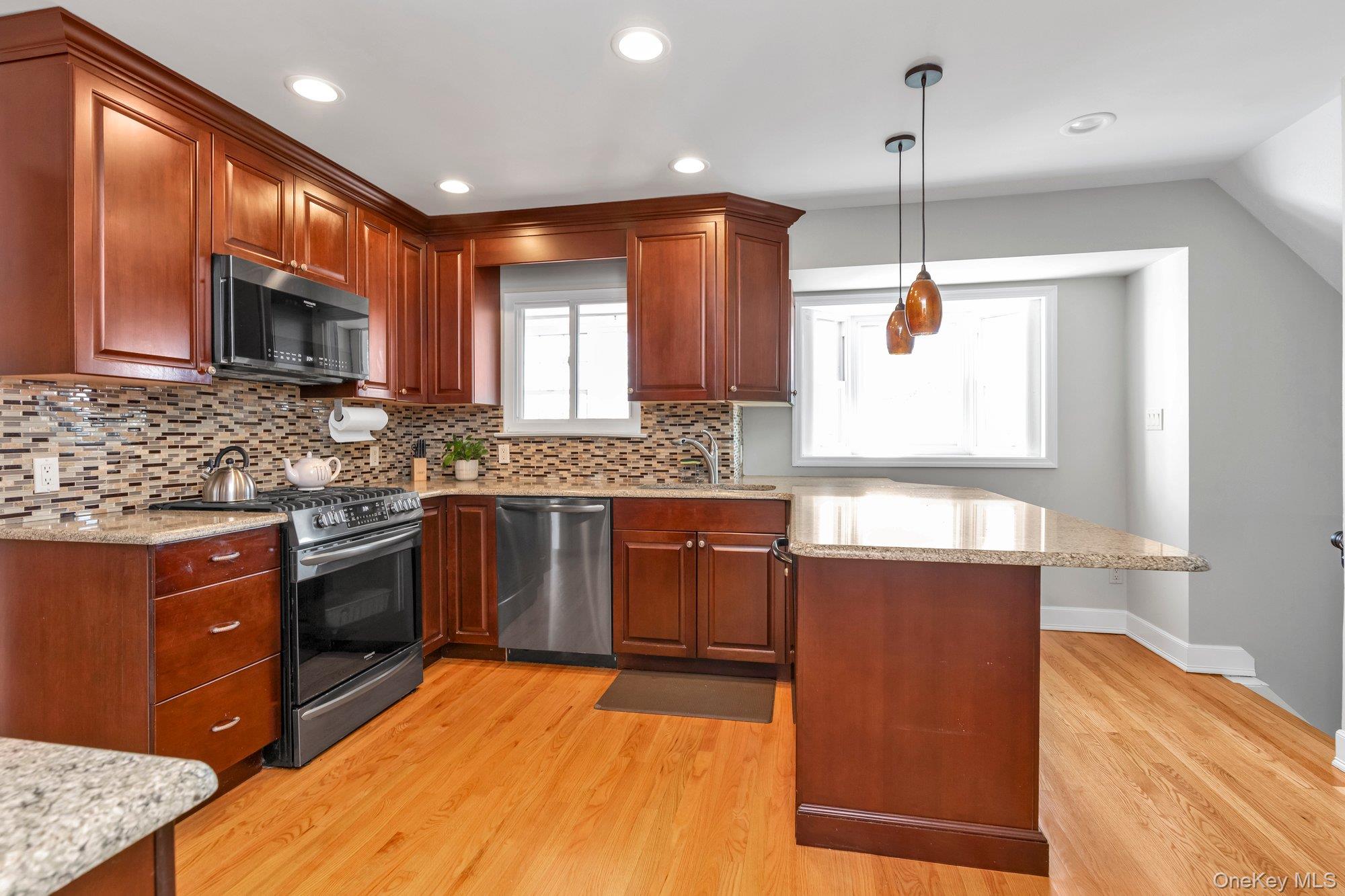 2038 Ripley Lane Merrick, NY 11566 - Photo 5 of 22 Spacious Eat-in-Kitchen with Wood Cabinetry, Granite Countertops and Center Island