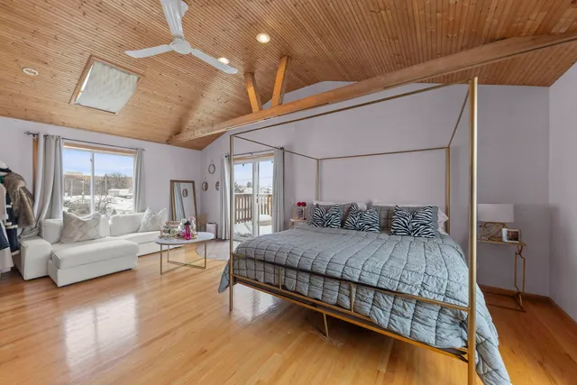 a bedroom with a bed couch and a large window