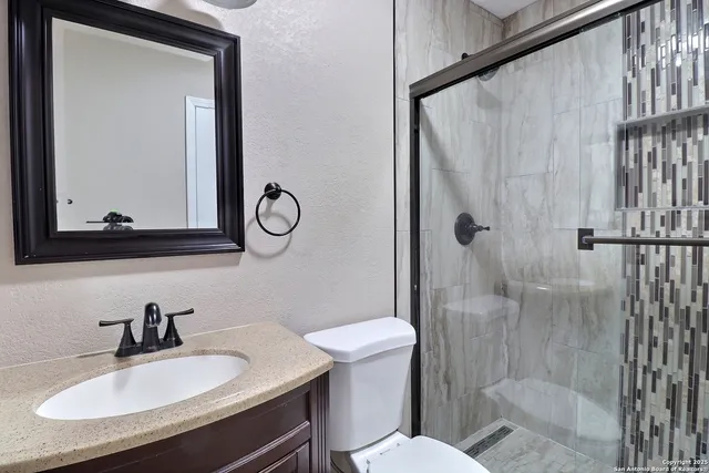 a bathroom with a sink toilet a mirror and shower