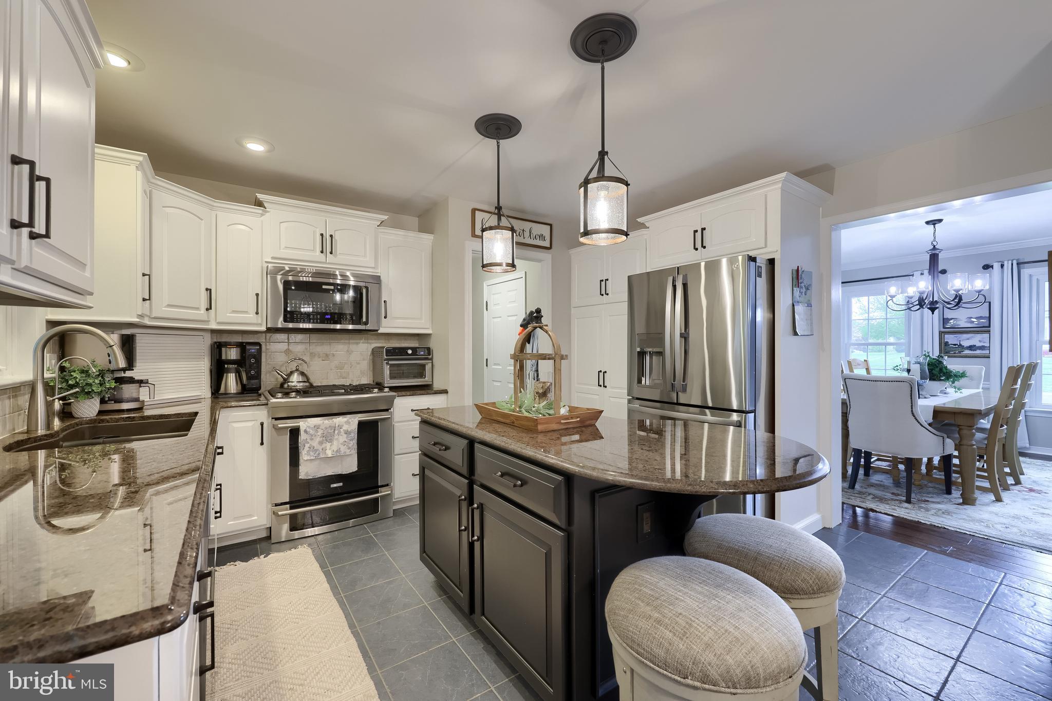 315 Royal Hunt Way Lititz, PA 17543 - Photo 17 of 67 a kitchen with stainless steel appliances kitchen island granite countertop a sink a stove a refrigerator cabinets and chairs