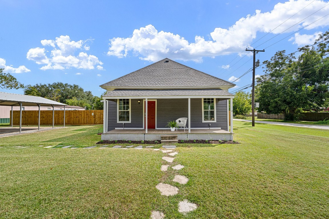 a view of a house with a yard and sitting area