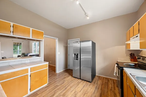 a kitchen with stainless steel appliances wooden floor sink and wooden cabinets