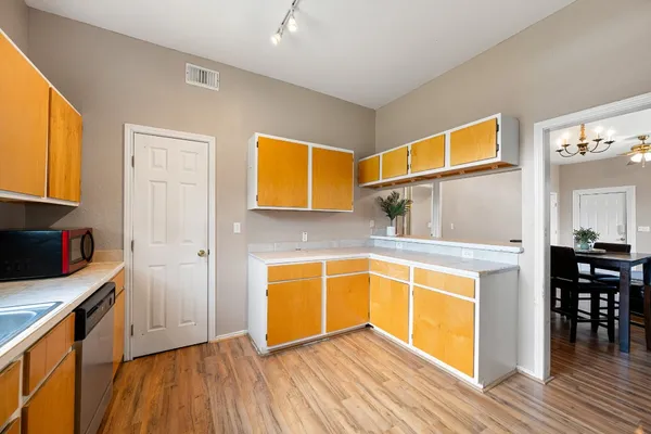 a view of a kitchen with wooden floor and electronic appliances