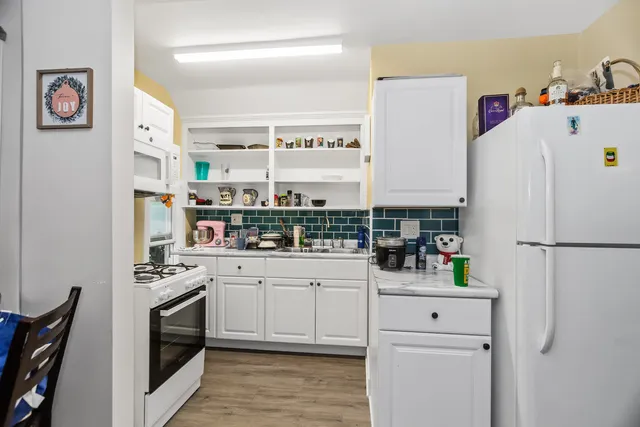 a kitchen with a sink a refrigerator and cabinets
