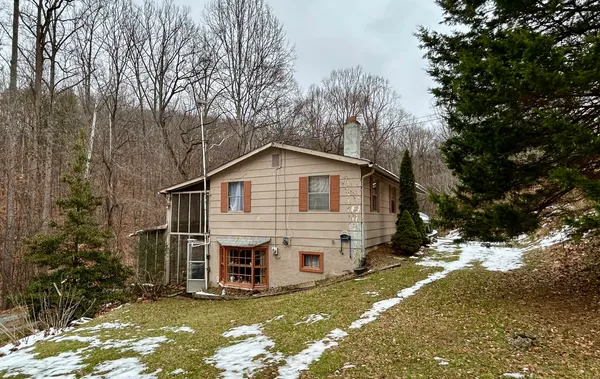 a view of a house with a yard covered in snow