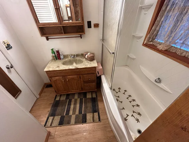 a bathroom with a tub sink and mirror