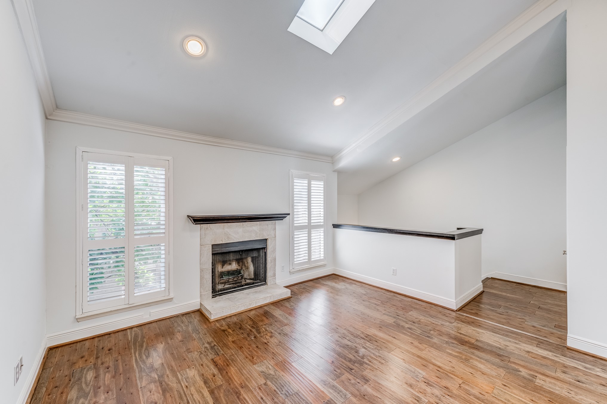 708 Fowler Street Houston, TX 77007 - Photo 5 of 42 an empty room with wooden floor fireplace and windows