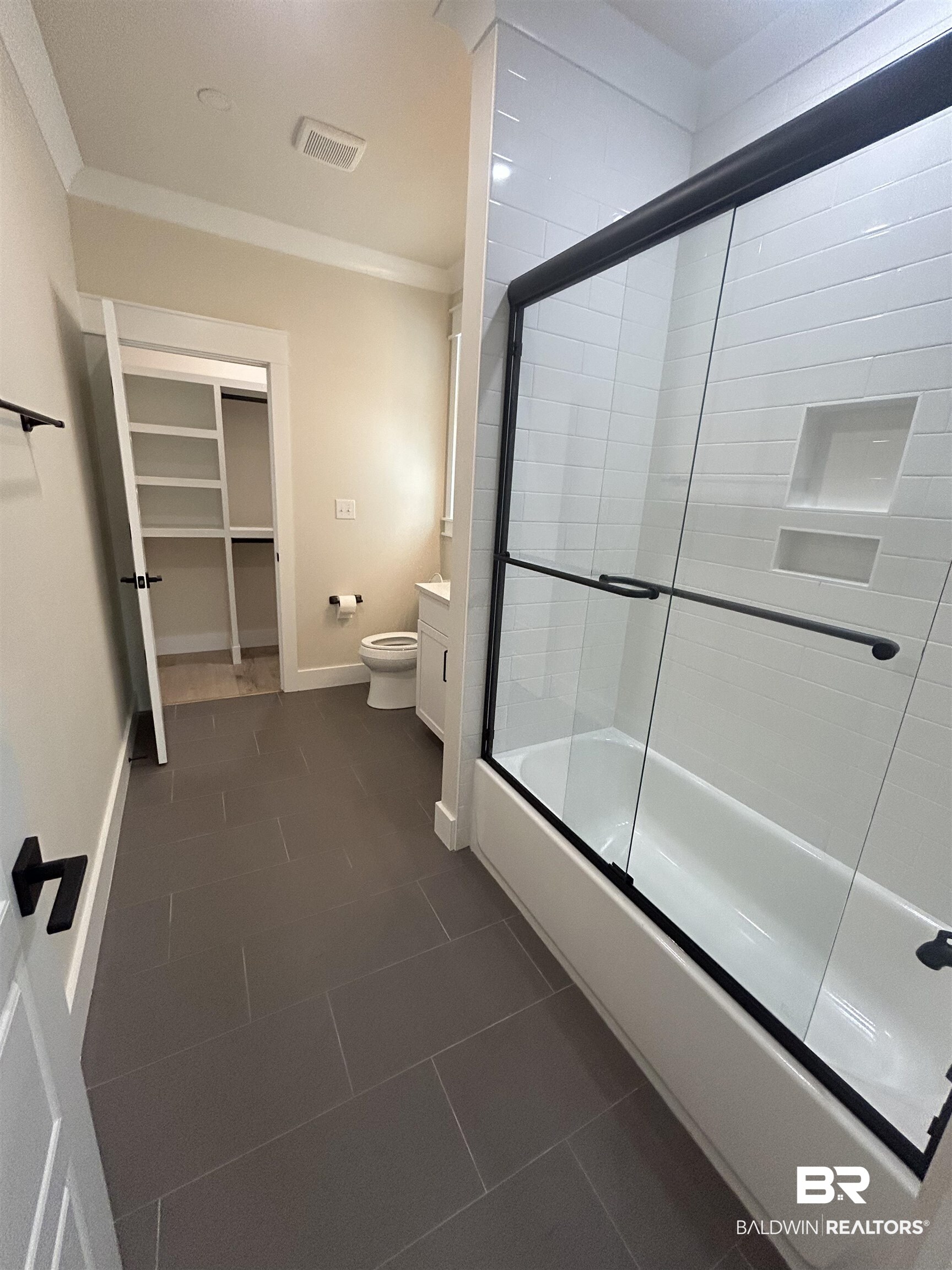 5122 Pine Road Orange Beach, AL 36561 - Photo 13 of 24 Full bathroom with ornamental molding, shower / bath combination with glass door, a spacious closet, and dark tile patterned flooring