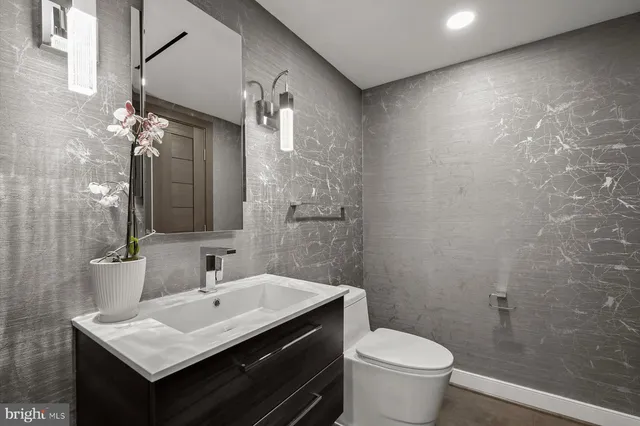 a bathroom with a sink toilet and mirror