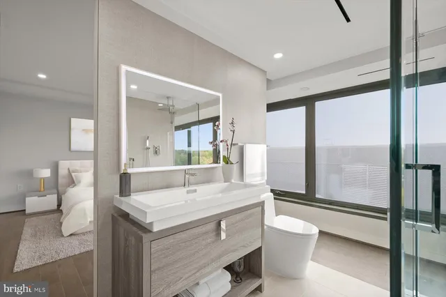 a bathroom with a sink a toilet and a large mirror