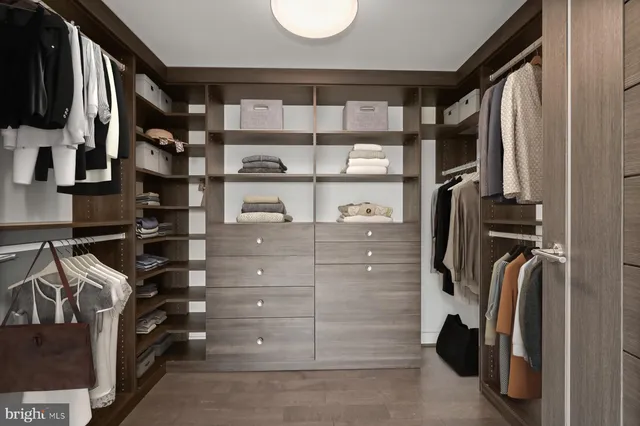 a view of walk in closet with clothes and shoes