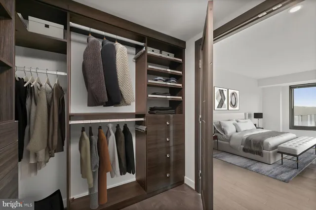 a view of walk in closet with clothes and shoes