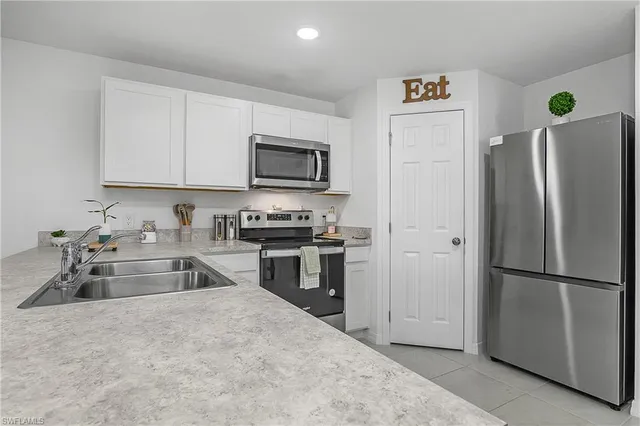 a kitchen with granite countertop a refrigerator stove and microwave
