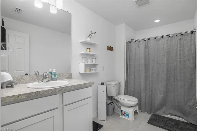 a bathroom with a granite countertop sink toilet a mirror and shower