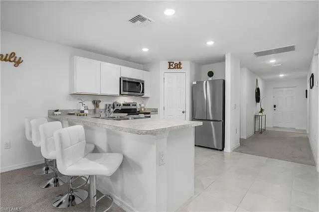 a kitchen with stainless steel appliances a refrigerator and a stove top oven