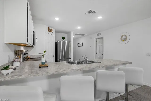 a kitchen with stainless steel appliances granite countertop a sink and a refrigerator