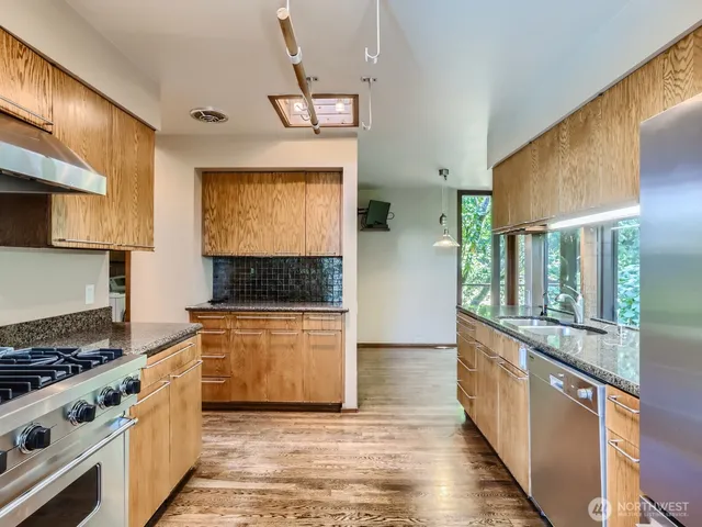 a kitchen with stainless steel appliances granite countertop a stove and a sink