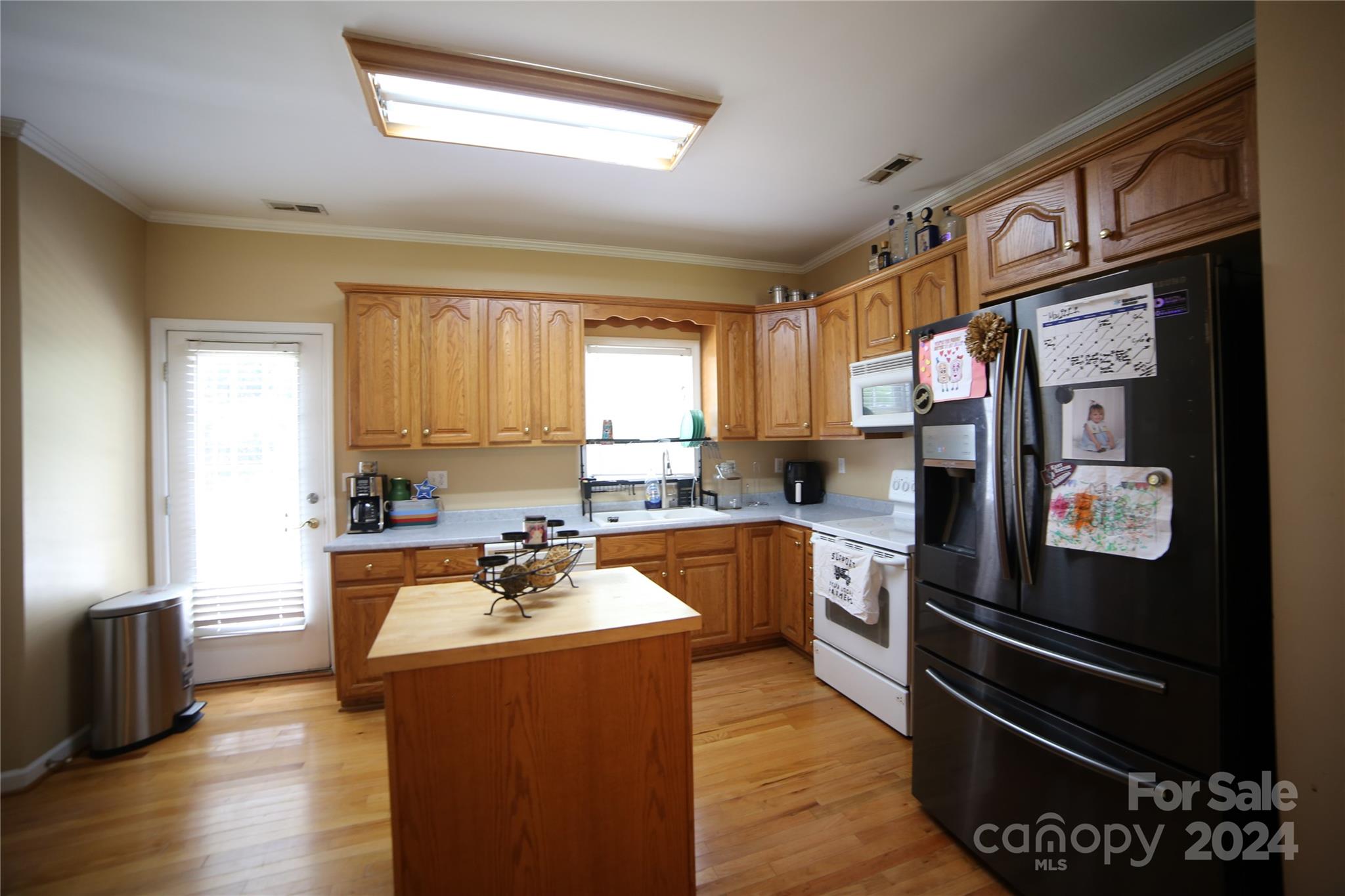 1117 Blacksnake Road Stanley, NC 28164 - Photo 9 of 27 a kitchen with stainless steel appliances granite countertop a refrigerator a sink dishwasher a stove and white countertops with wooden floor
