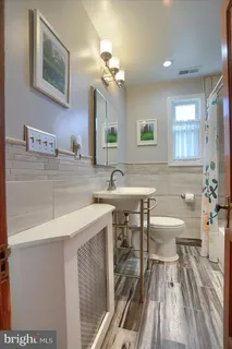 a bathroom with a sink a toilet and a mirror