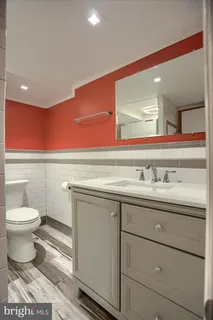 a bathroom with a sink a toilet and a mirror