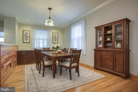 a view of a a dining room with furniture window and wooden floor