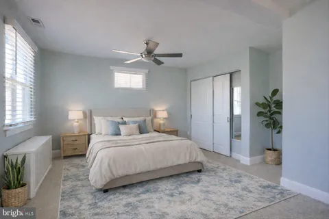 a bedroom with a large bed and a potted plant