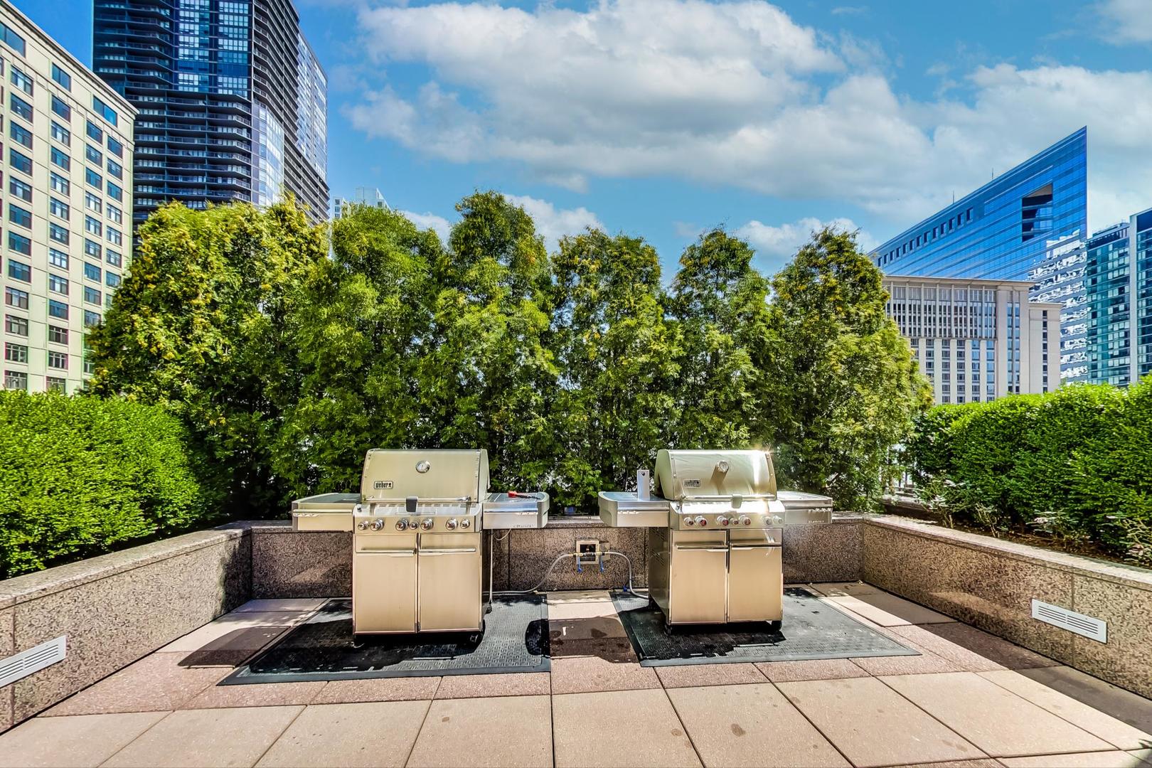 33 West Ontario Street, Unit 46C Chicago, IL 60654 - Photo 30 of 32 a view of a patio with table and chairs with potted plants