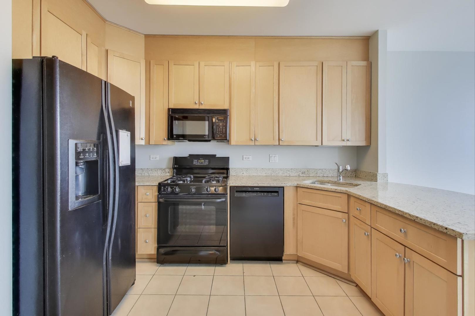 33 West Ontario Street, Unit 46C Chicago, IL 60654 - Photo 10 of 32 a kitchen with a refrigerator sink and cabinets