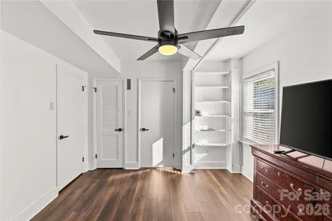 a view of a livingroom with wooden floor and a ceiling fan