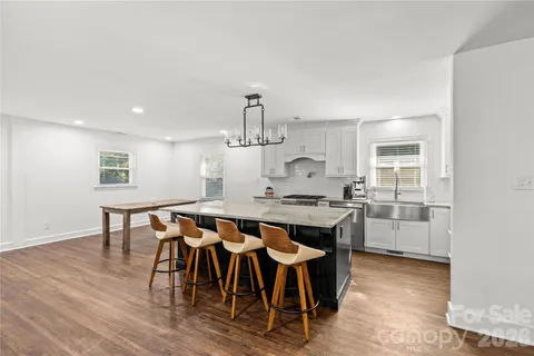 a dining room with a table chairs and kitchen view