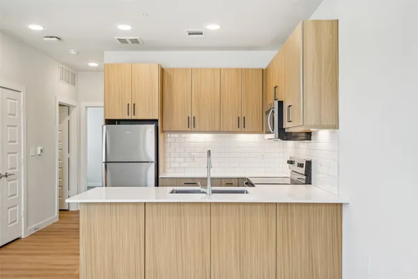 a kitchen with kitchen island granite countertop white cabinets and refrigerator