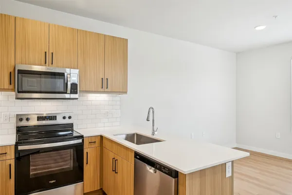 a kitchen with stainless steel appliances a stove microwave and sink