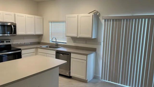a kitchen with a white cabinets and white appliances