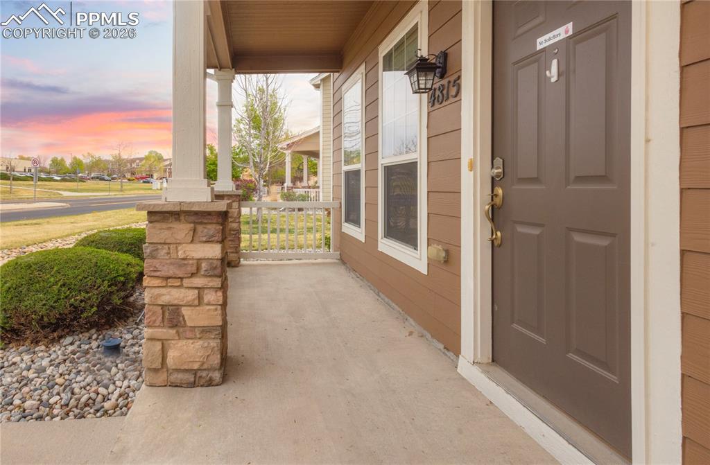 4815 Harrier Ridge Drive Colorado Springs, CO 80916 - Photo 4 of 33 Exterior entry at dusk with a porch