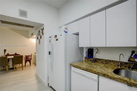 a kitchen with stainless steel appliances granite countertop a sink refrigerator and cabinets