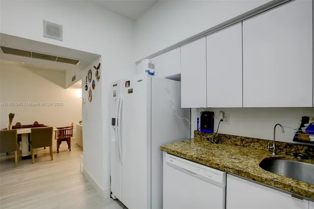 a kitchen with stainless steel appliances granite countertop a sink refrigerator and cabinets