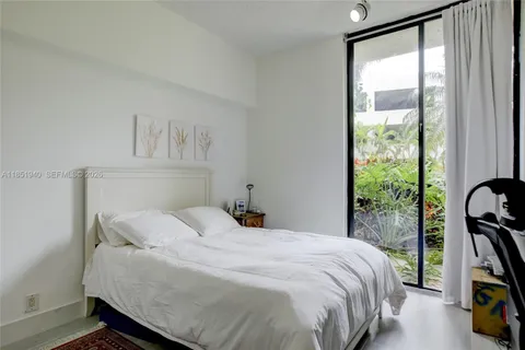 a bedroom with a bed and a large window